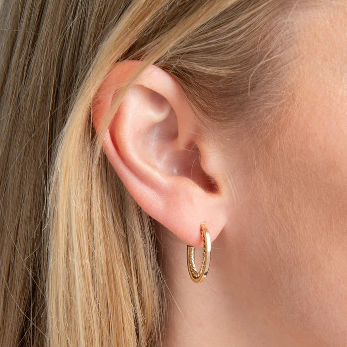 9ct yellow gold rope twist open hoop earrings with polished edges close up on the model