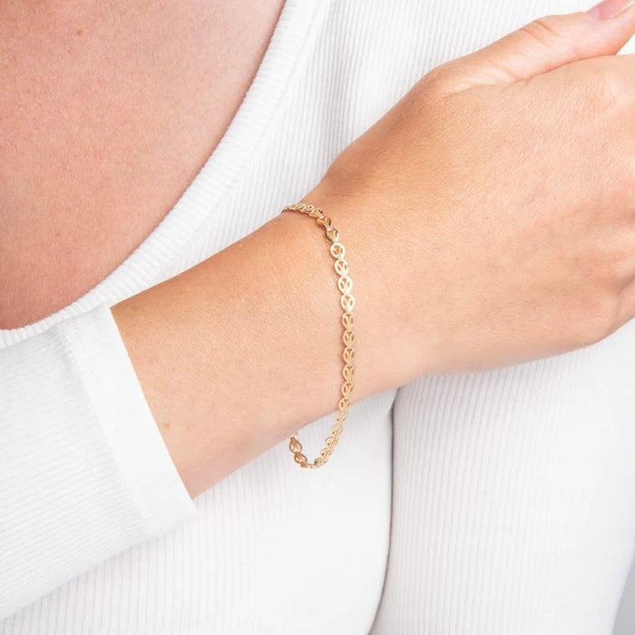 9ct yellow gold Stampato link bracelet with polished finish on the model