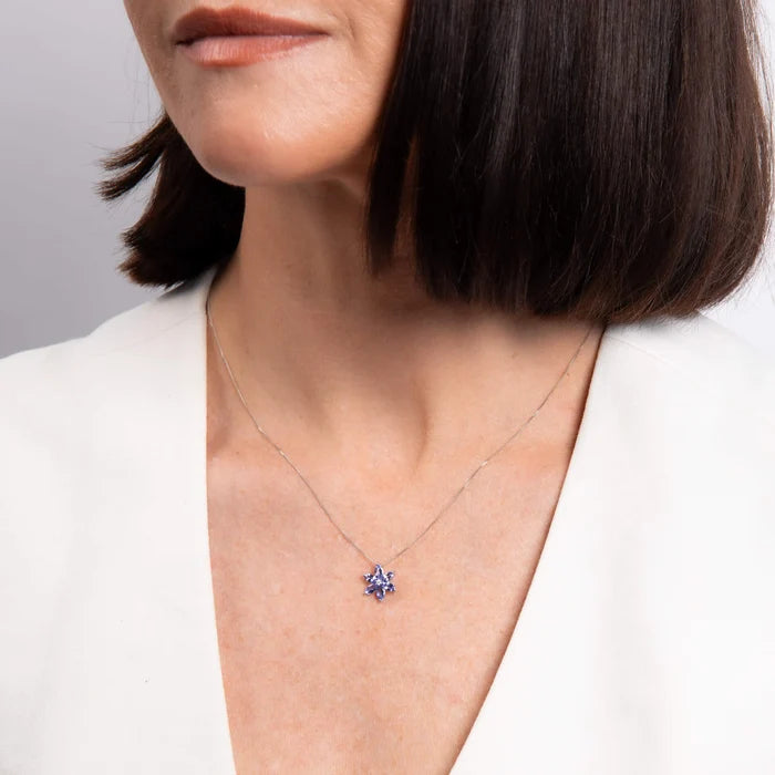 Model wearing 9ct white gold tanzanite and diamond flower pendant