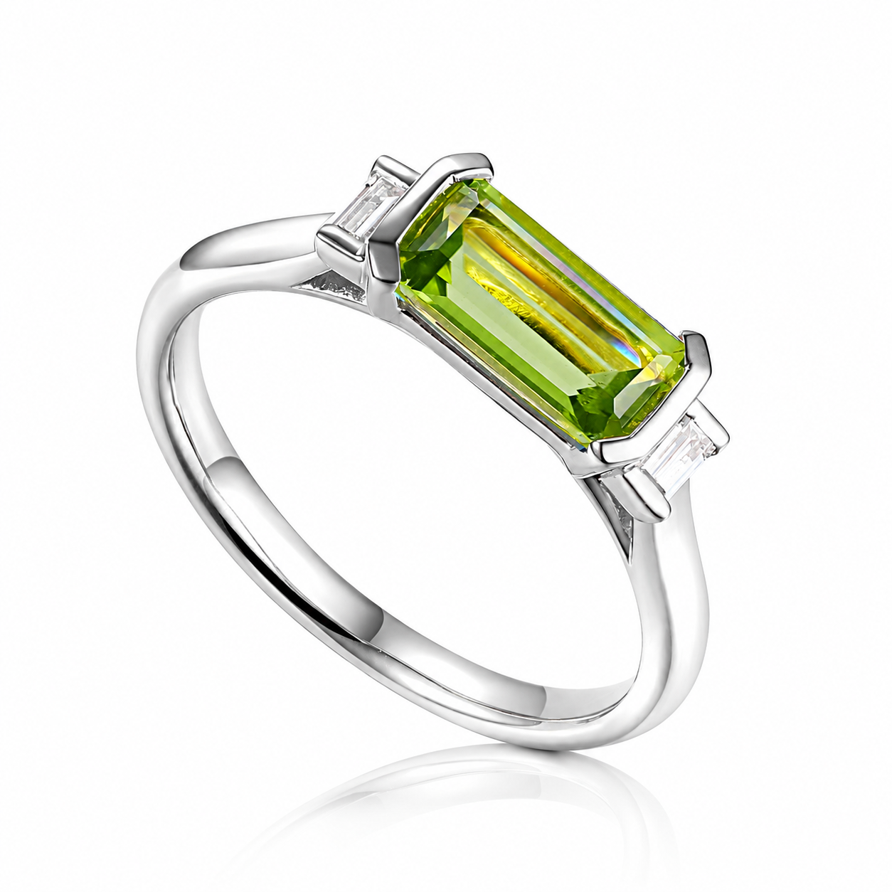White gold ring featuring a natural octagon cut peridot with two baguette cut diamonds in a contemporary rub-over setting
