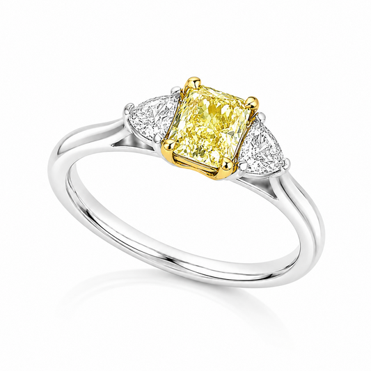 The Sol platinum trilogy ring with GIA-certified 0.71ct VS2 natural Fancy Yellow radiant cut diamond and white diamond side stones.
