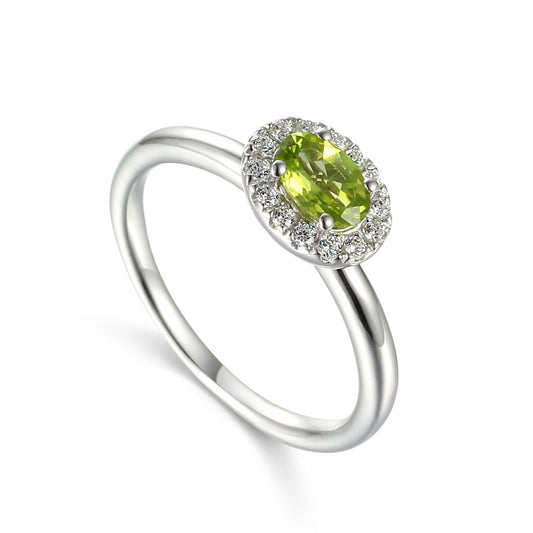 9ct white gold ring featuring a 5 × 4mm oval cut natural peridot surrounded by a sparkling diamond cluster