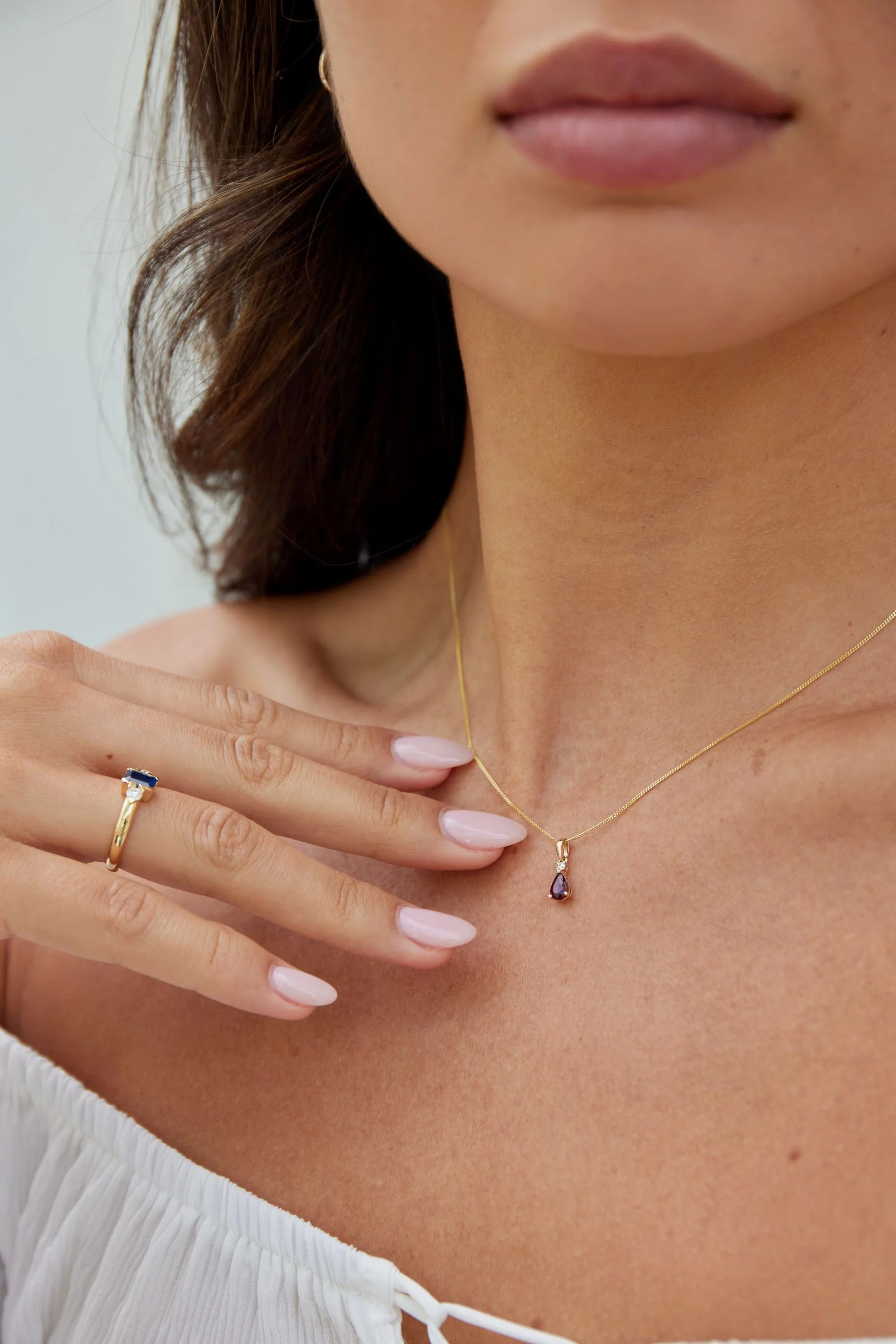 Model wearing a yellow gold pear cut peridot and diamond pendant from the Pear Birthstone Collection