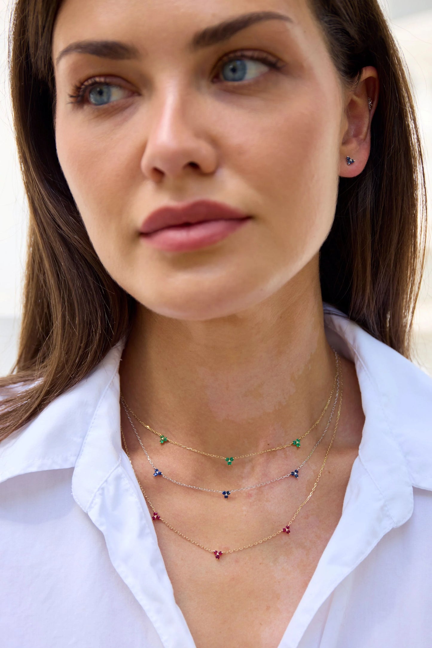 Model wearing a yellow gold triple peridot necklace from The House of Gemstones collection
