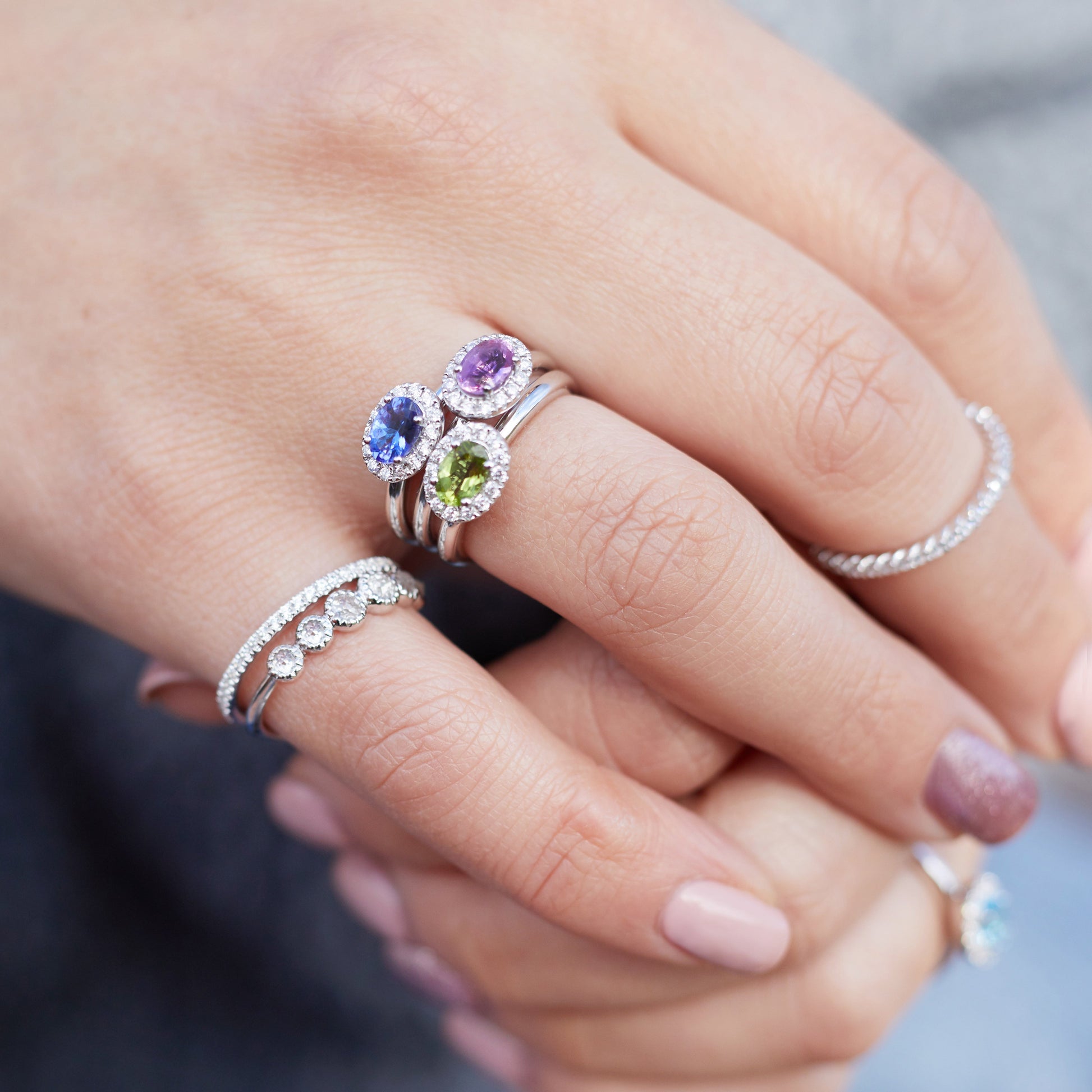 Model wearing a 9ct white gold oval peridot and diamond cluster ring from The House of Gemstones collection