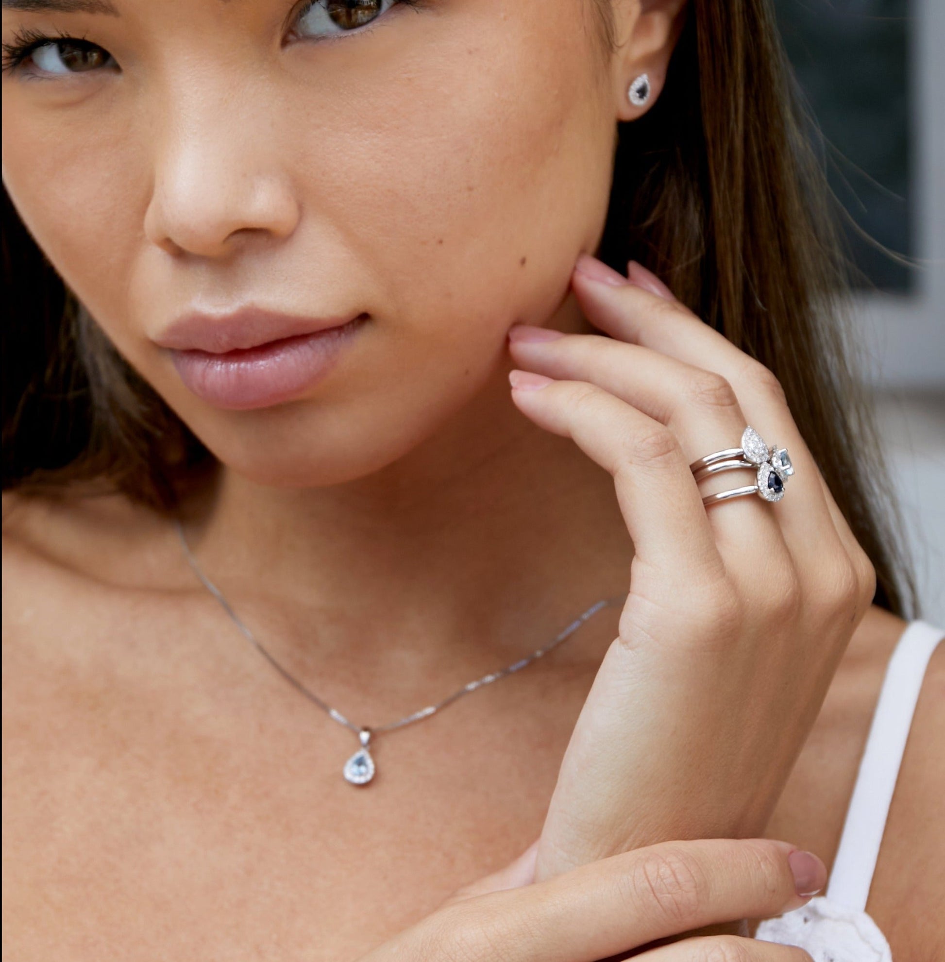Model wearing 18ct white gold pear cut gemsotne and diamond stud earrings from the Pear Birthstone Collection