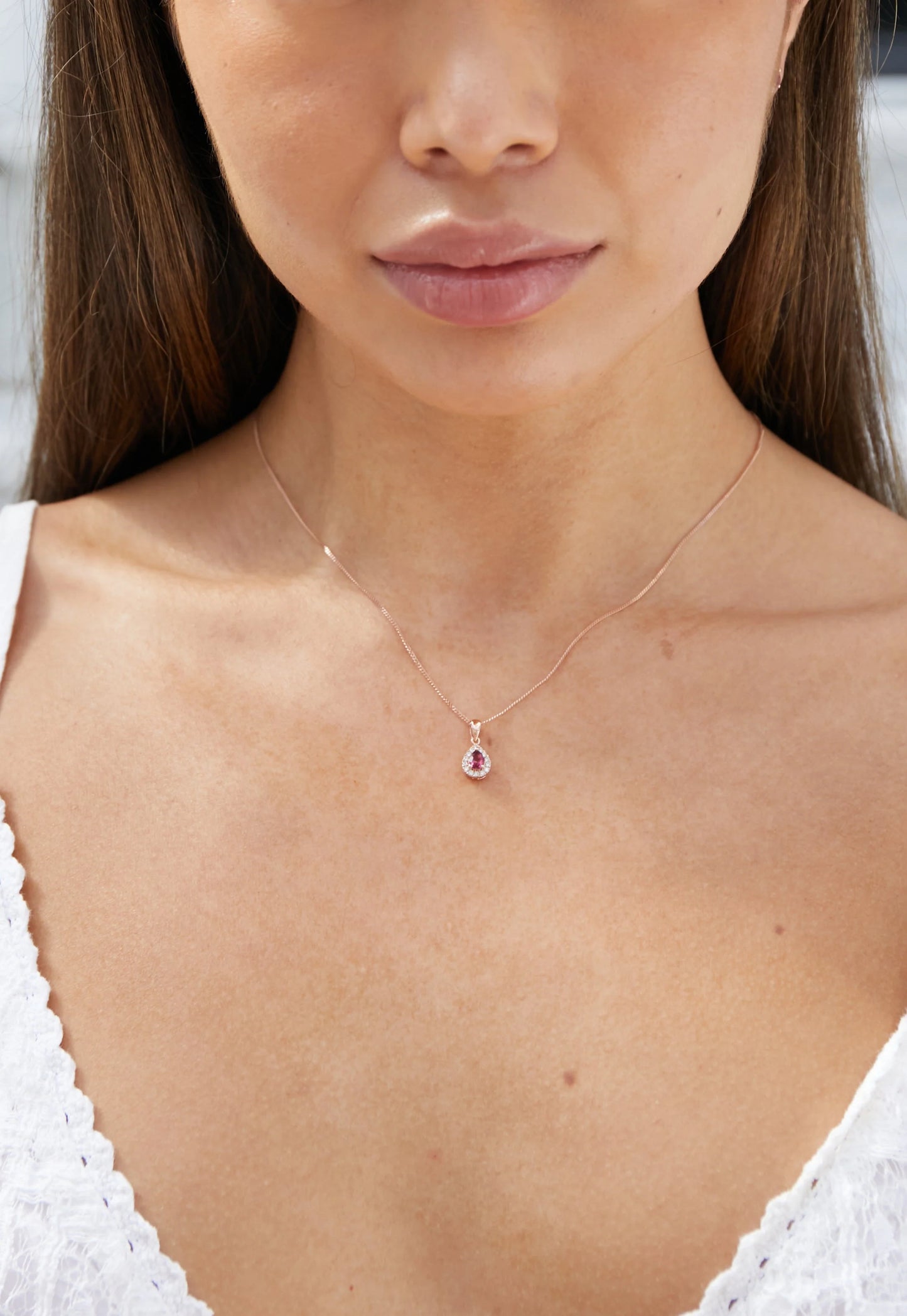 Model wearing a pink tourmaline and diamond cluster pendant in white gold