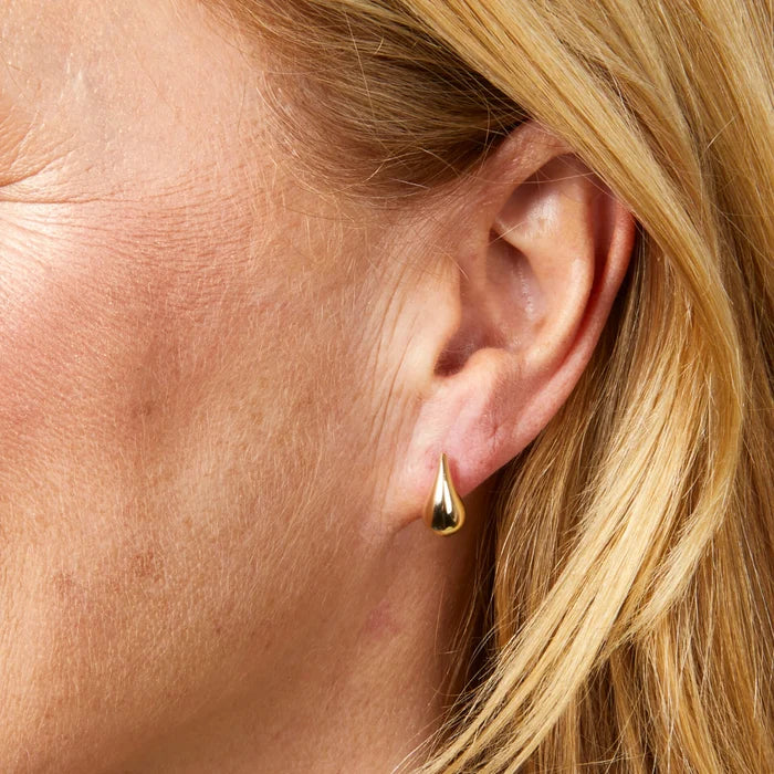 9ct yellow gold sculpted teardrop stud earrings with polished finish close up on the model