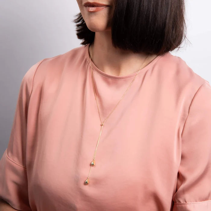 9ct yellow gold organic teardrop lariat necklace with polished finish on the model
