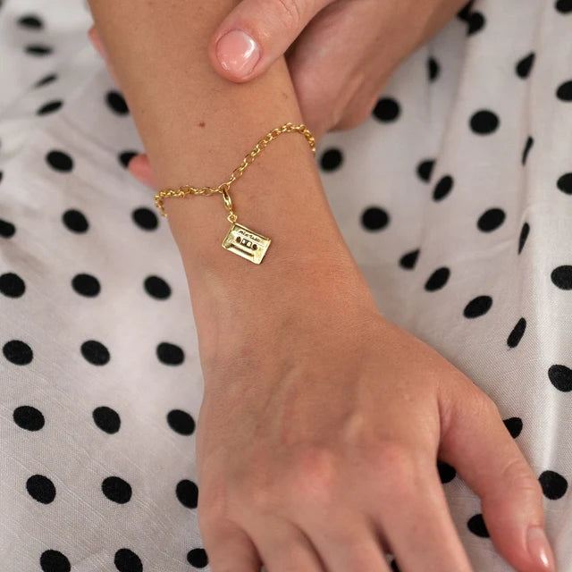 Gold cassette tape charm by Lily Charmed in 18ct gold-plated recycled sterling silver on a bracelet 