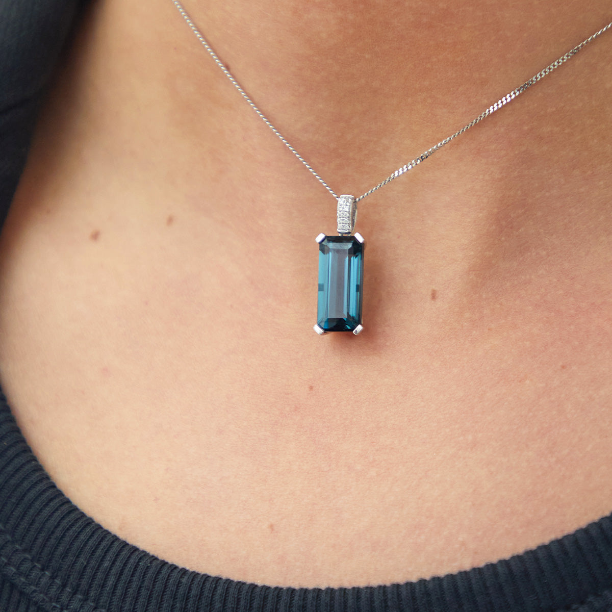Long octagonal London Blue Topaz with double row pavé diamond detail in white gold